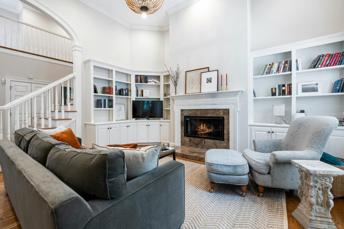 Cozy living room interior featuring a fireplace, bookcases, and comfortable seating.